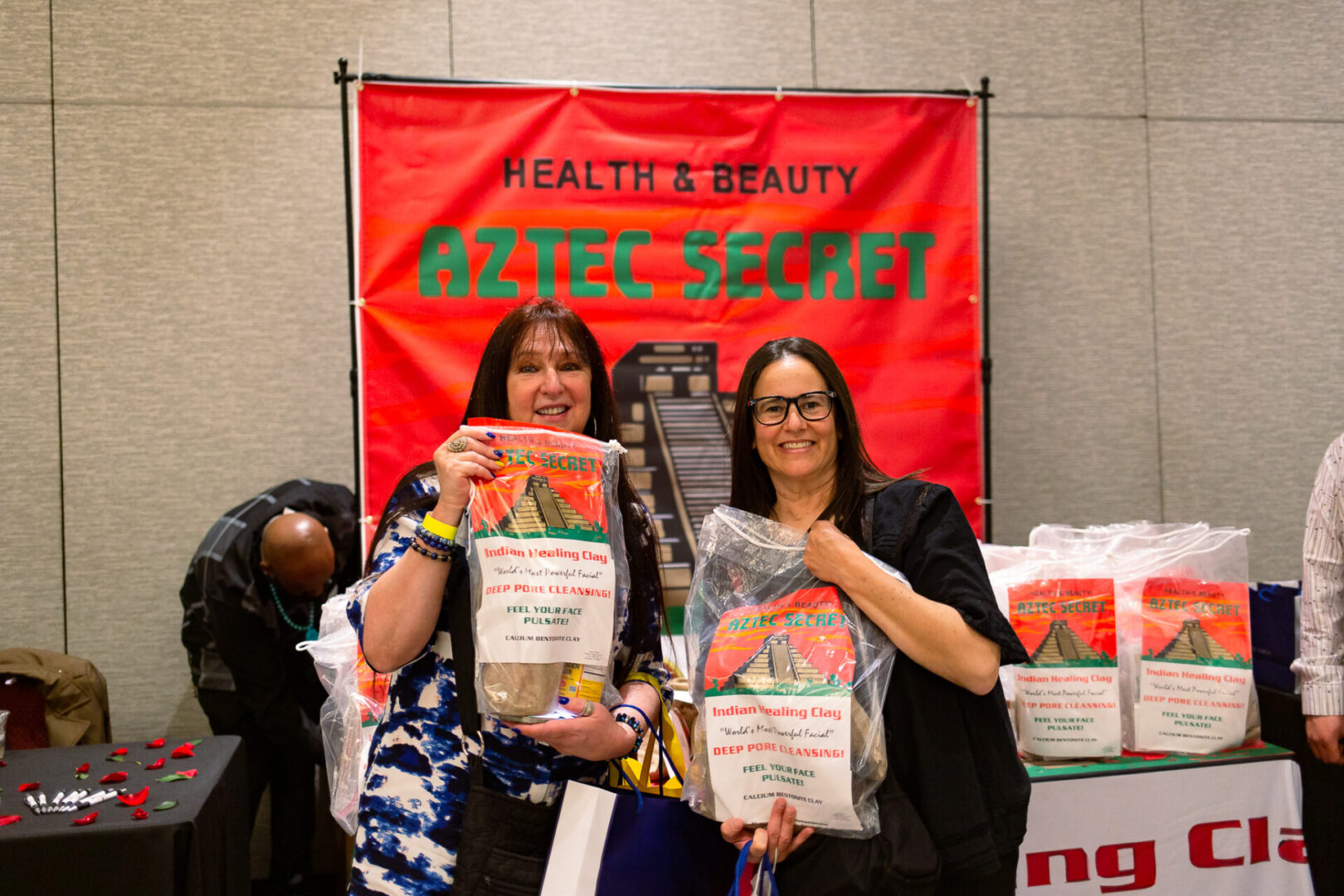 Two women holding a bag of Aztec Secret Health & Beauty LTD Indian healing clay