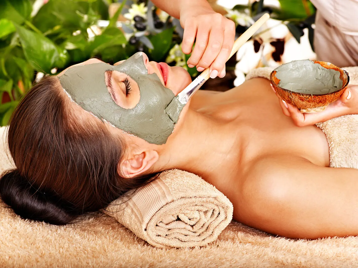 Beautiful woman having clay facial mask apply by beautician. | Aztec Secret Health & Beauty LTD