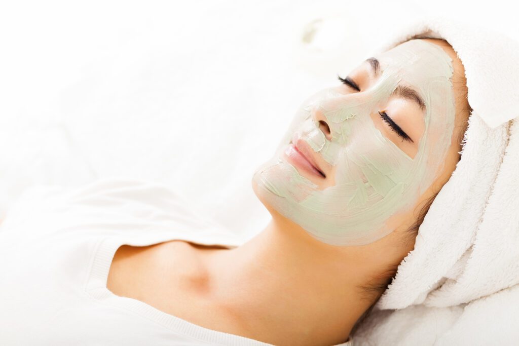 Young beautiful woman with clay facial mask